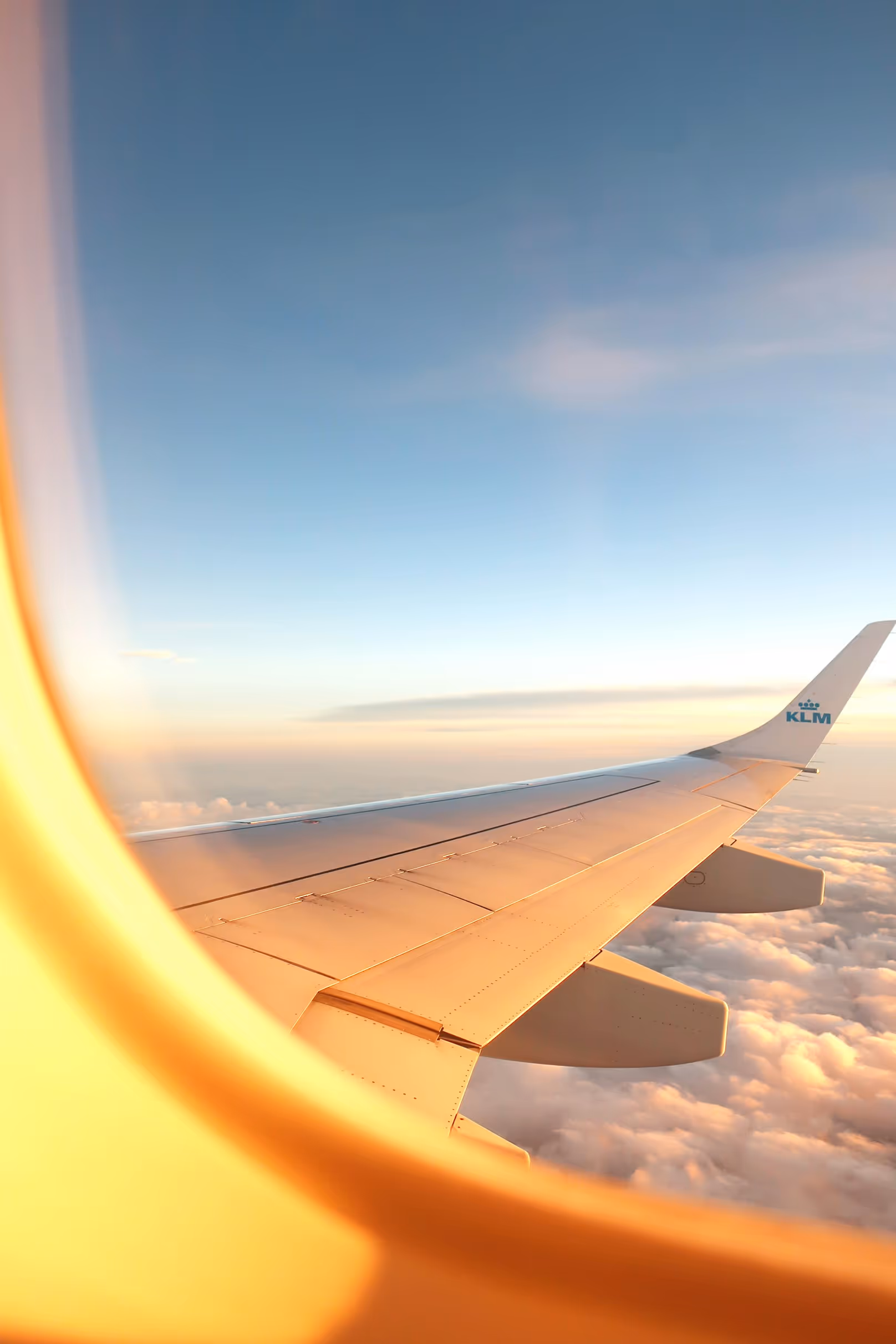 A plane window with clouds in view